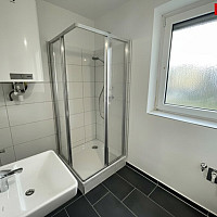 Badezimmer nach Sanierung mit Dusche und Fenster Symbolfoto