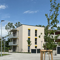 Wohnhaus mit Balkonen und Bäumen